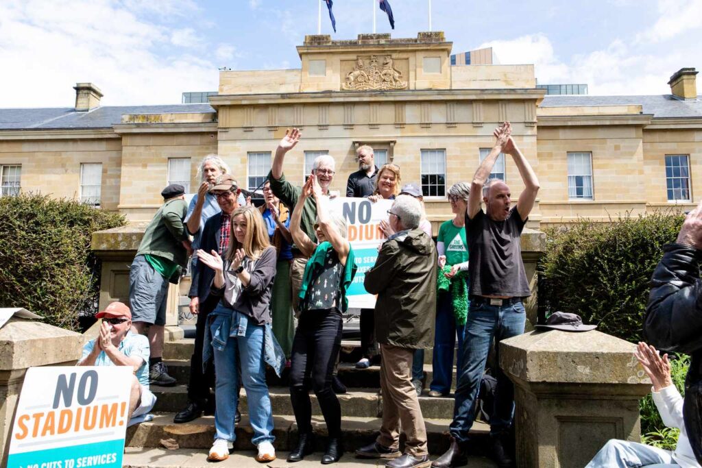 Crowd rallies against Macquarie Point stadium on Parliament Lawns ...
