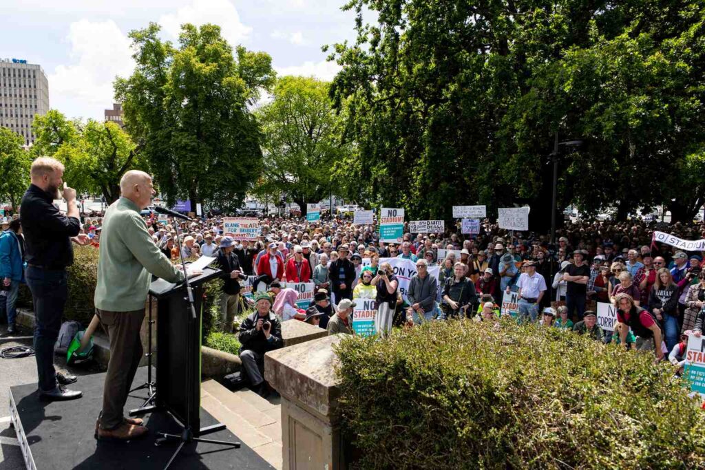 Crowd rallies against Macquarie Point stadium on Parliament Lawns ...